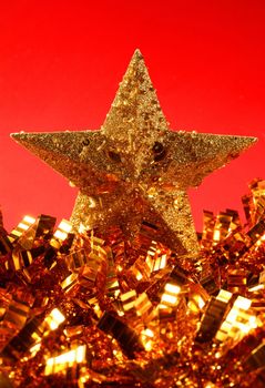 Christmas golden decoration with gold star over red background