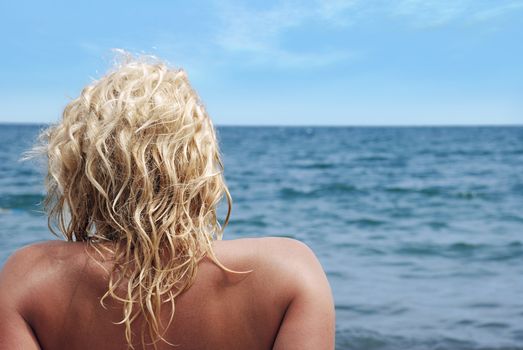 The effective blonde on a sea beach (a swarty sunburnt leather)