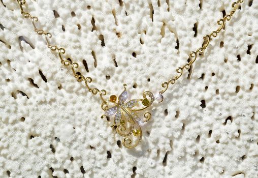 Gold necklace on a background from a sea coral