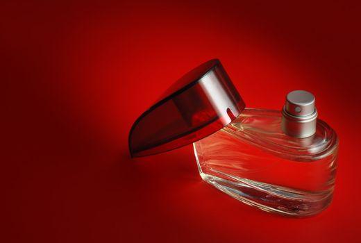 perfume. A bottle perfume on a red background with effective illumination