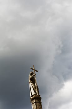 Sculpture of a Saint holding a cross in a catholic cemetery, Portugal