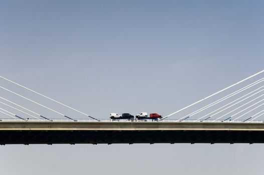 Truck with cars crossing a bridge