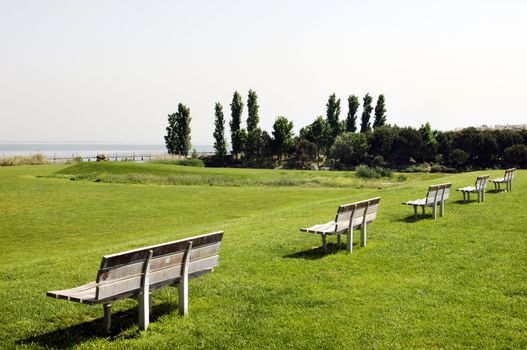 Row of benches in a lawn near the Tagus river, Portugal