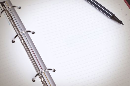 Close-up image of blank spiral organizer with black marker pen