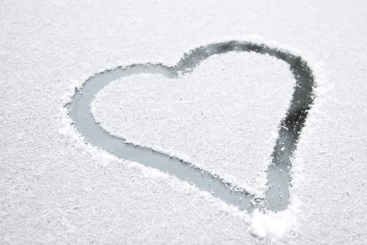 Heart shape drawn on white snow, love symbol for Valentine Day, selective focus