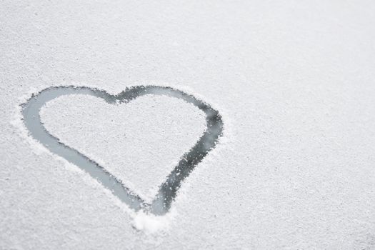 Heart shape drawn on white snow, love symbol for Valentine Day 