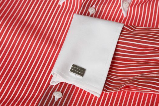 Close-up of cuff link on men's red shirt 