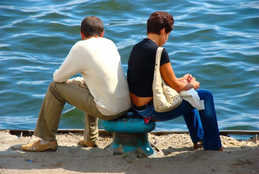 Tiff. Man and woman sitting on the bank of the river