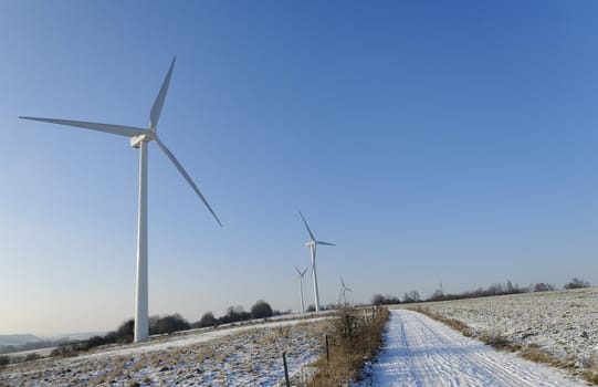 a country lane in winter with windmills in the background