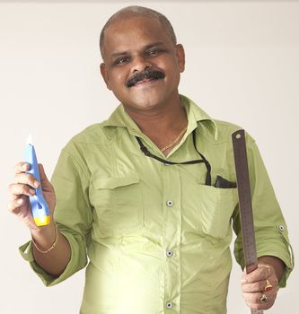 smiling Indian journeyman with tools of his trade on a light background