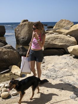 Woman with dog at the seaside in a tropical country