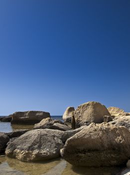 Fallen limestone boulders and rocks near coastline in Gozo in Malta