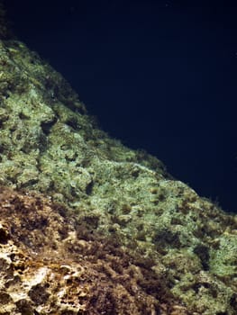 Detail of a rocky reef in Malta with beautiful crystal clear ocean water