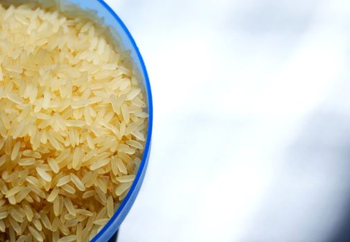 blue sauser with raw rice isolated against white background