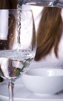 Pouring water into a glass into a wine glass