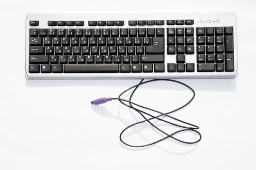 Computer keyboard with blue PS2 connector isolated on a white background. Lithuanian and russian letters.