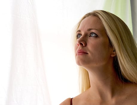 Beautiful blonde haired woman gazing out the window.
