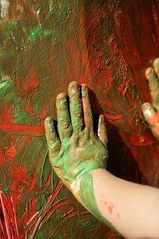 Children artist hands painting multi color with her fingers