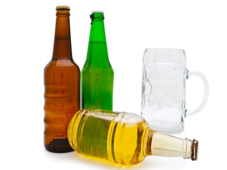 hree multicolored bottles of beer with glass against the white background