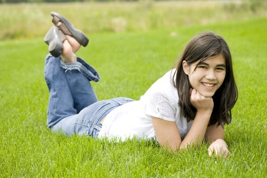 beautiful teen girl relaxing on lush green grass