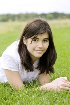 beautiful teen girl relaxing on lush green grass