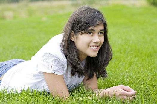 beautiful teen girl relaxing on lush green grass
