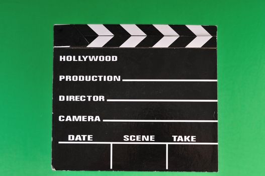 a movie marker or clapper board set against a green screen