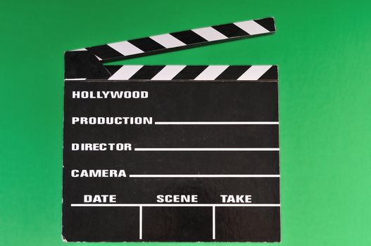 a movie marker or clapper board set against a green screen