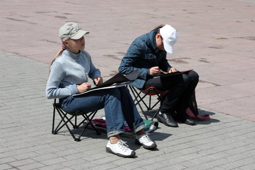 Young artists in the street draw from life