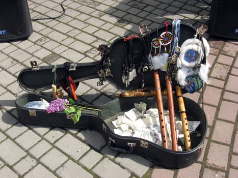 Case of a guitar with musical instruments and money