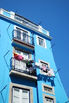 blue traditional building with clothes drying at the window