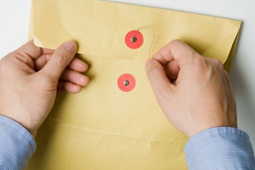 Person opening a confidential official document in an envelope