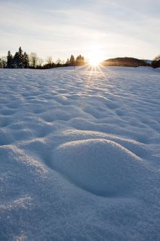 Sunrise or sunset against a snow covered landscape, winter background