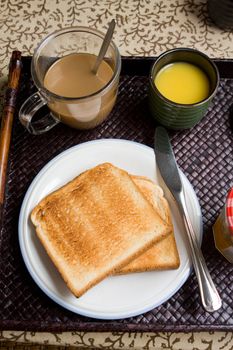 Breakfast meal with toast bread, coffee, orange juice, apples, marmalade