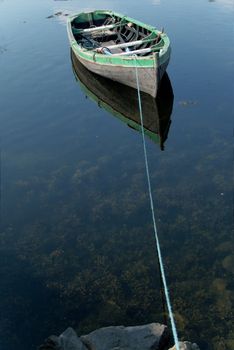 Small rowboat on a lake tied to the shore