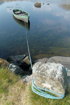 Small rowboat on a lake tied to the shore