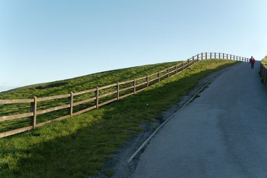 Man walking on a fenced country path