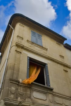 Open window with orange valance  in stone house