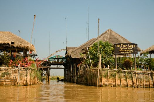 Village house on Inle lake standing on stilt and made from bamboo and palm leafs is accessible only via small boat.