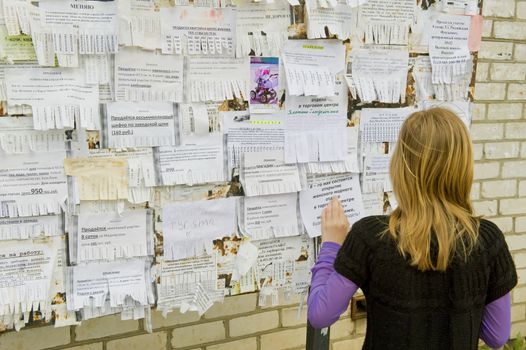 The girl looks through announcements on a board, taketin the Russian province on May 2011
