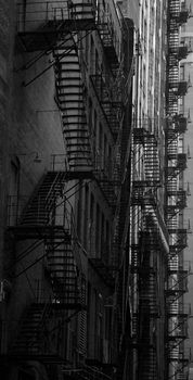 Chicago fire escape ladders in a dark alley in black and white
