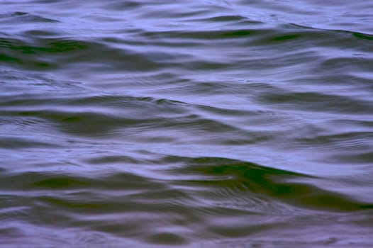 Blue brown light wave action on the surface of lake Michigan on a calm day