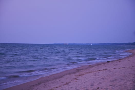 Lake michican coastline at dusk with sky, water, and sand