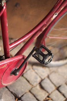 vintage red bike on a cobbled road