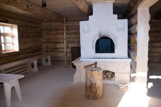 The interior of the old Russian log hut with a Russian stove.