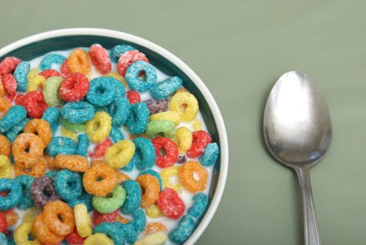 A bowl of fruit rings cereal with milk.