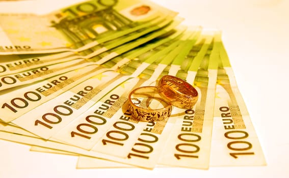 100 Euro notes on a white background and two rings.
