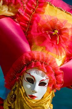 Carnival in venice with model dressed in various costumes and masks - orange lady