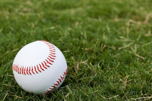 Closeup of baseball on grass with copy space.
