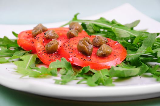 Salad with fresh tomatoes, capers and arugula